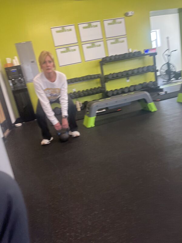A coach spotting a member during a lunge